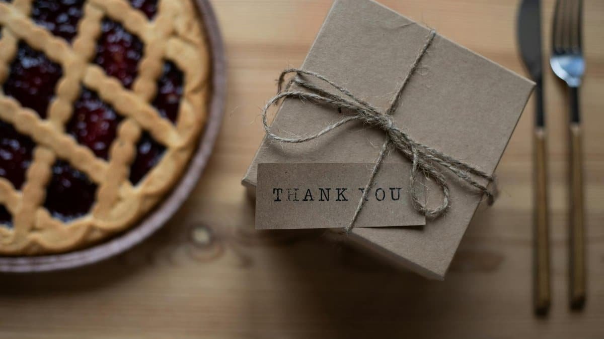A rustic thank you gift box beside a cherry pie, perfect for celebrations.