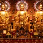 A stunning display of golden Buddha statues in a richly decorated temple. Intricate details enhance the sacred atmosphere.