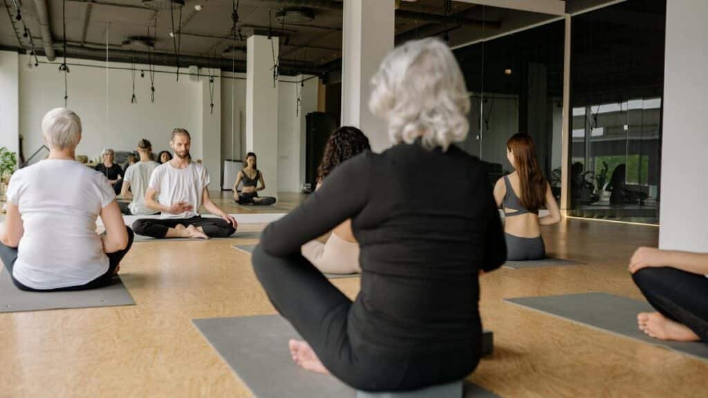 A diverse group practicing yoga in a modern, serene studio space promoting wellness.