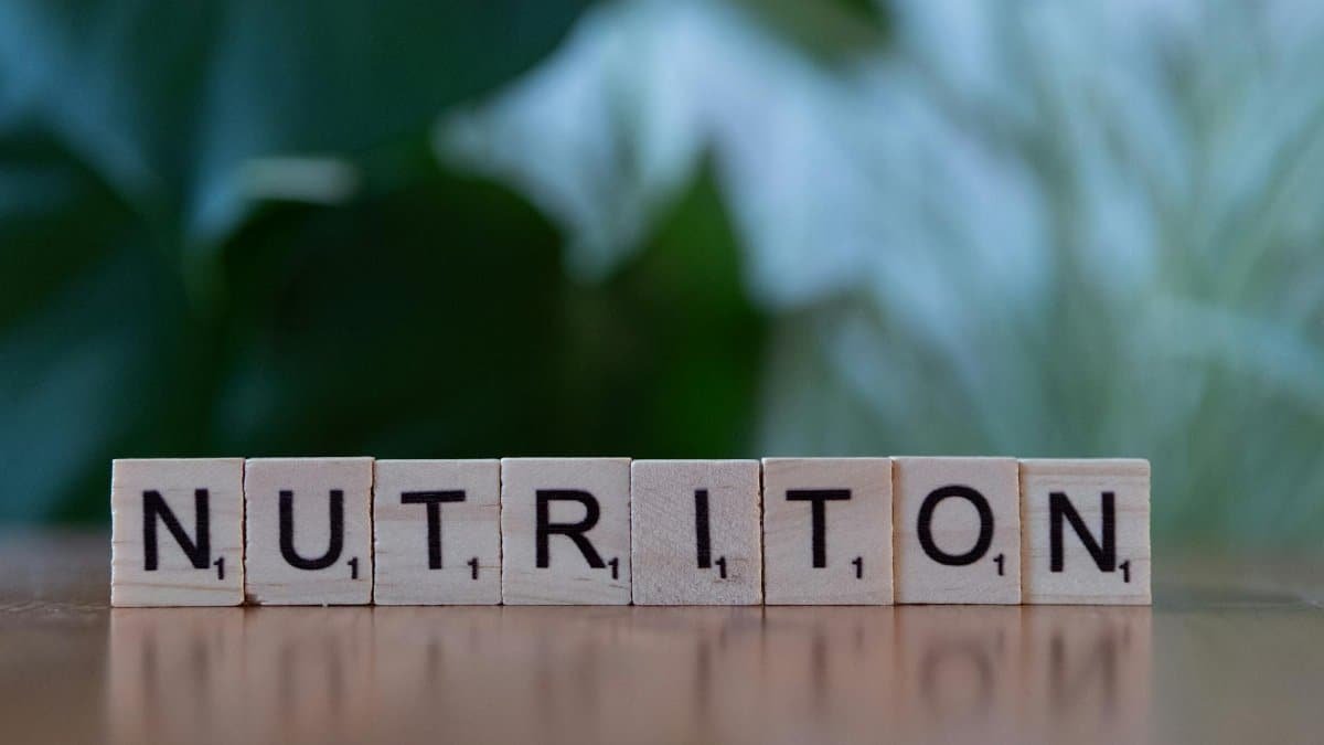 Wooden tiles spelling 'nutrition' on a table with blurred background.
