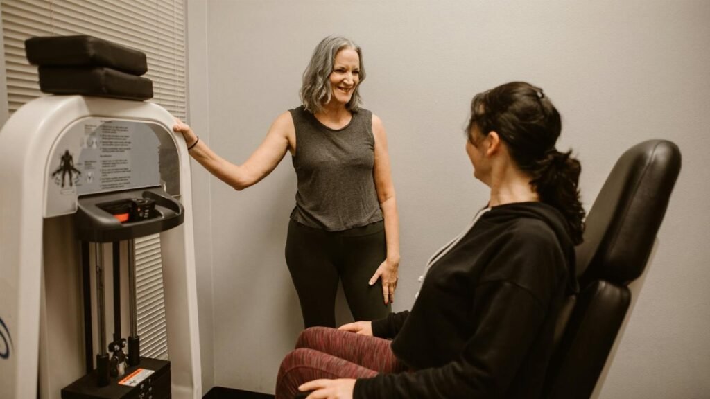 Two women exercising with gym equipment, promoting fitness and wellness indoors.