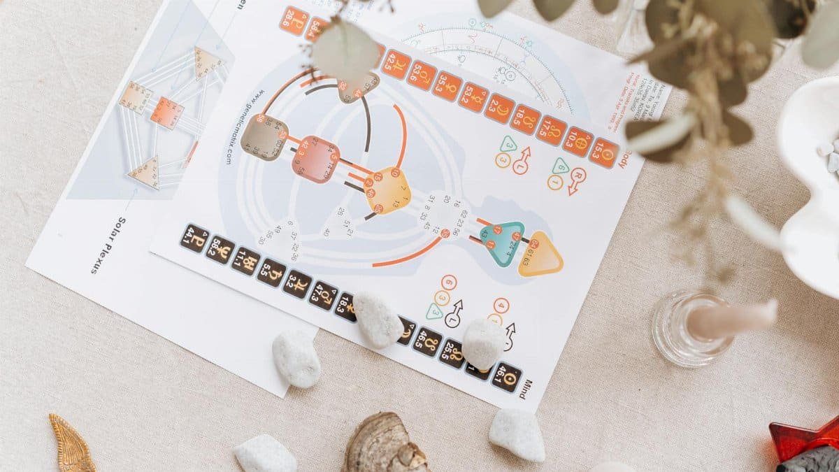 A serene setup of spiritual diagrams and crystals on a beige surface, symbolizing holistic healing and balance.