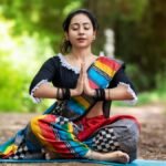 Woman practicing yoga outdoors in colorful attire, embracing mindfulness and inner peace.