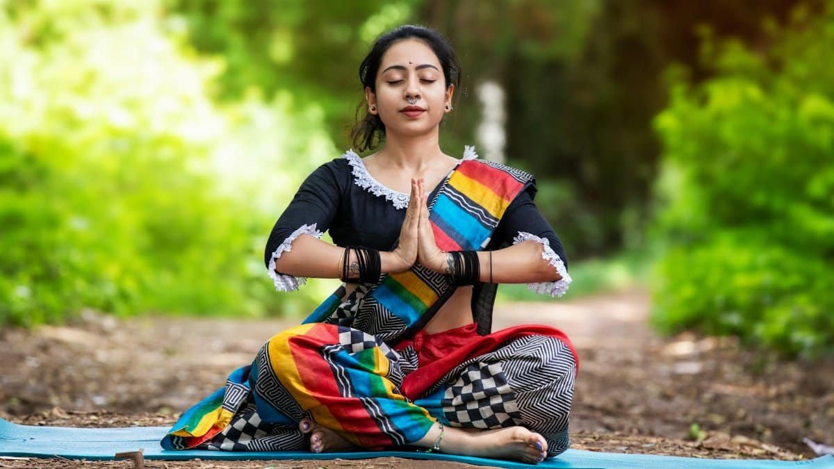 Woman practicing yoga outdoors in colorful attire, embracing mindfulness and inner peace.