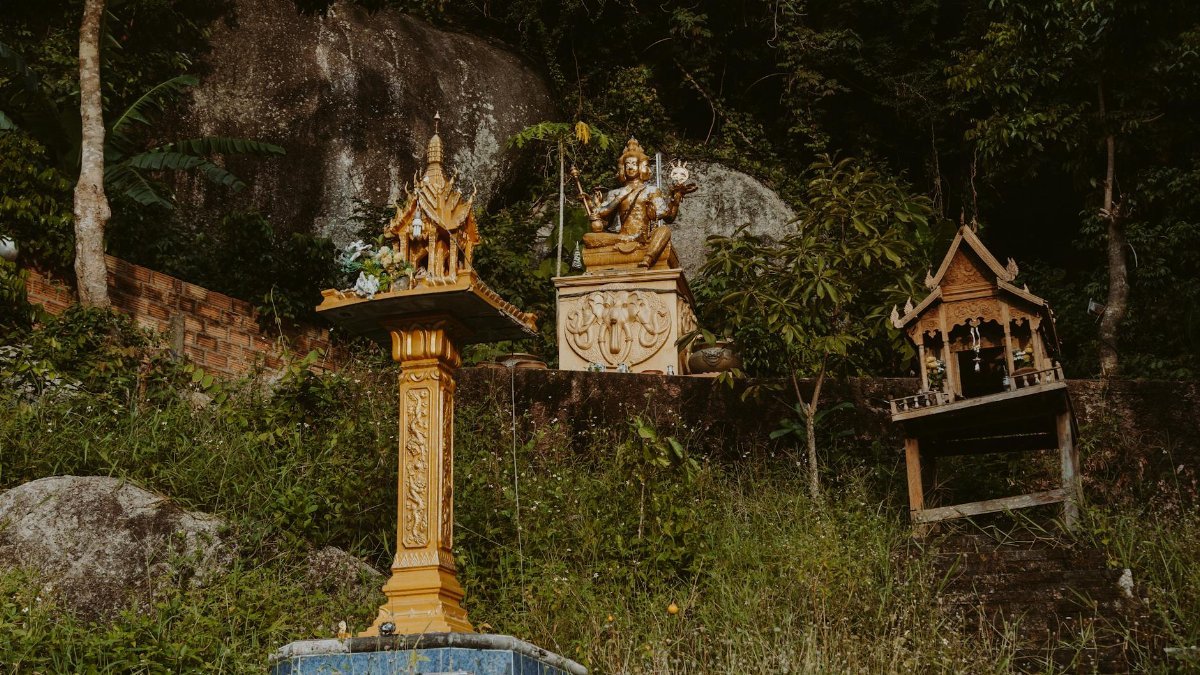 Serene Buddhist altars amidst lush greenery on a tranquil hillside setting.