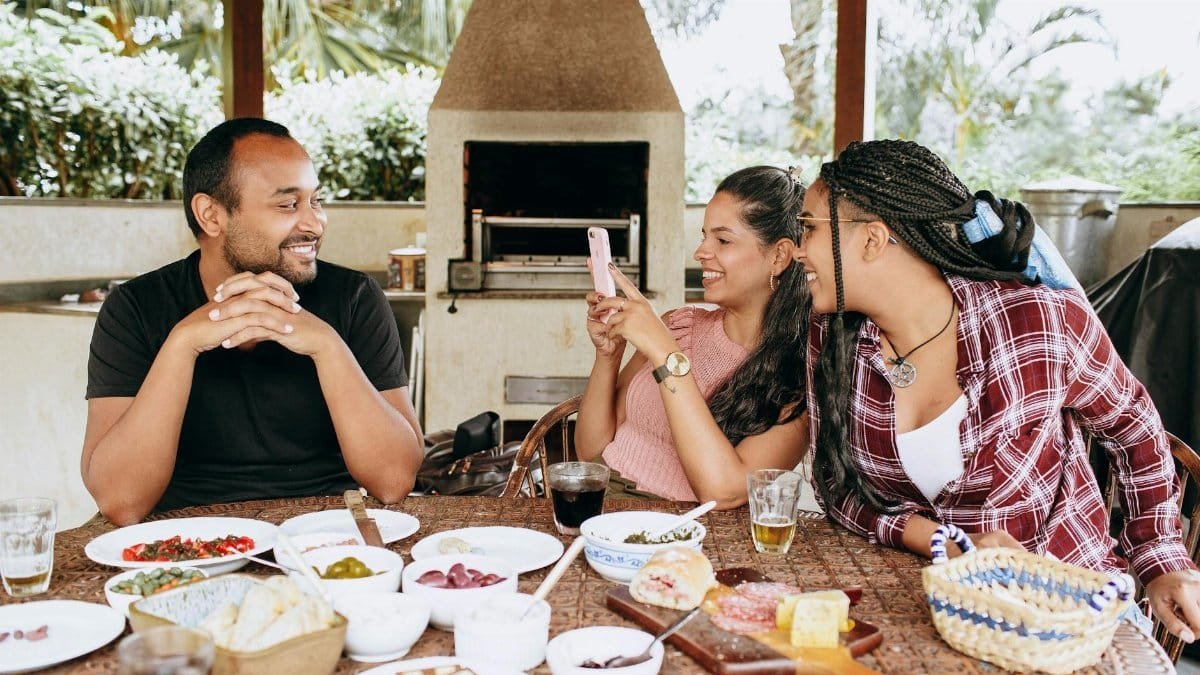 Friends enjoying a meal together outdoors, capturing a lively moment of conversation and connection.