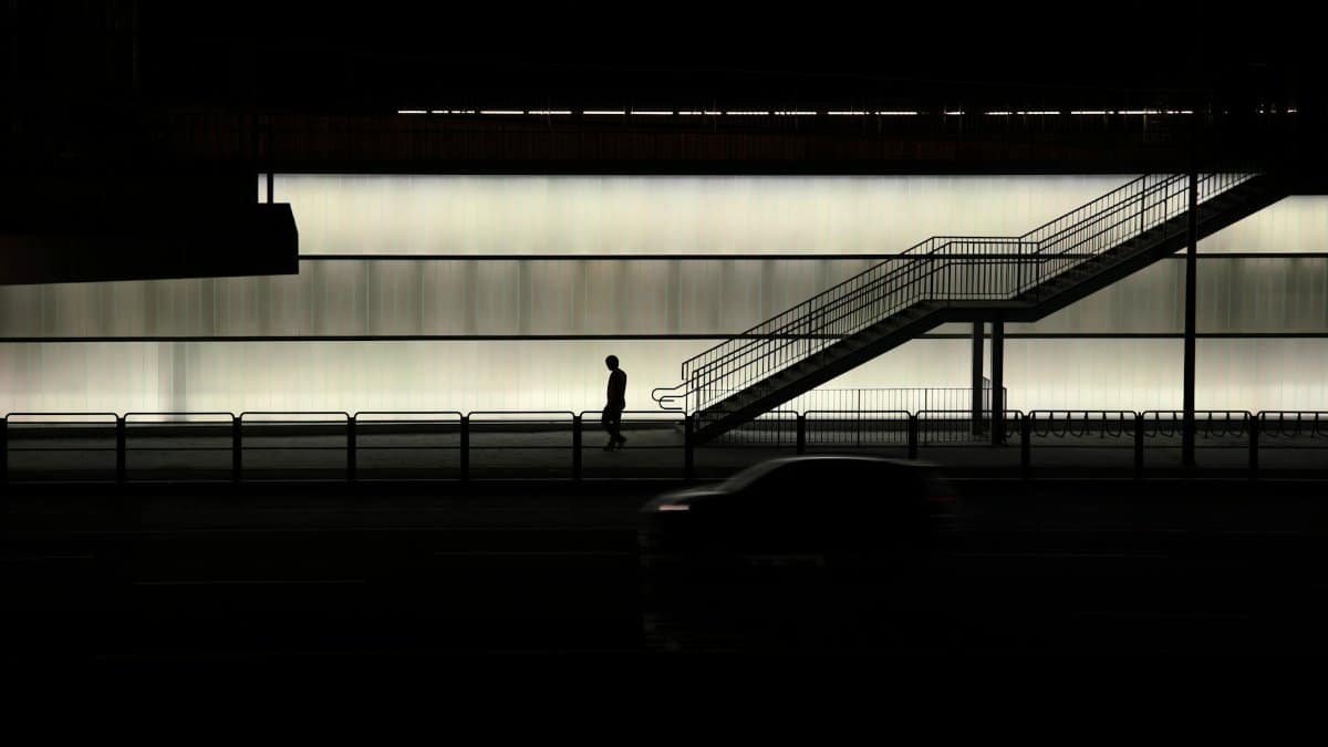 Nighttime scene in Seoul featuring a silhouette of a pedestrian against an illuminated wall.