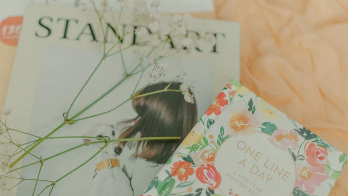 Close-up of floral notebooks and magazines with gentle pastel tones, ideal for creative journaling.