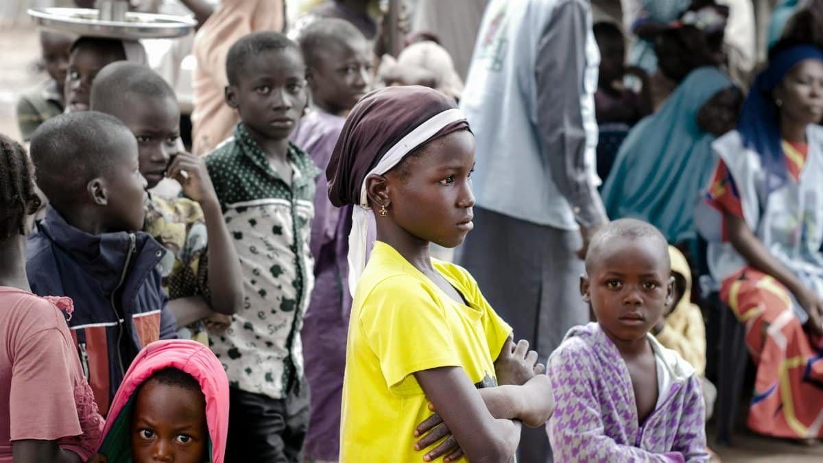 A group of children gathered together outdoors in Abuja, Nigeria, showcasing diversity and community.