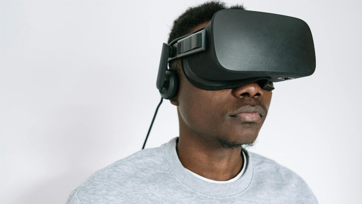 A man using a VR headset, experiencing virtual reality technology indoors.
