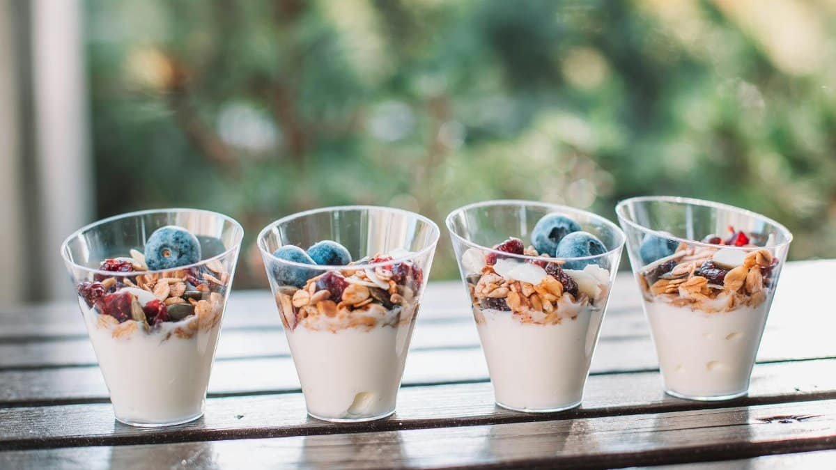 Healthy yogurt parfaits topped with fresh blueberries, nuts, and granola.