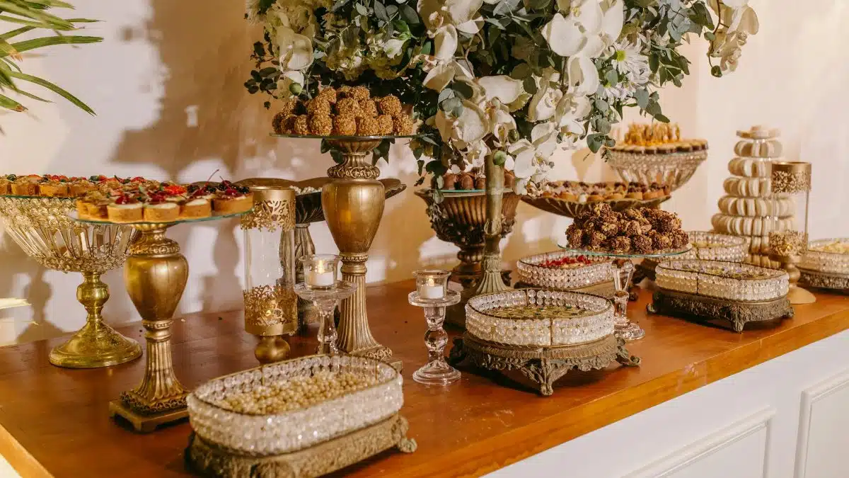 Elegant dessert table with luxurious floral arrangements and ornate platters.