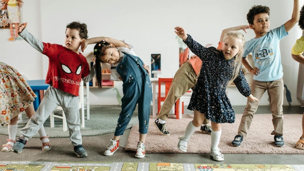 Group of diverse preschool children engaging in fun exercises indoors.