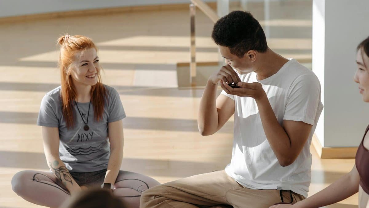 A diverse group of adults enjoying a yoga session in a bright, sunlit room.