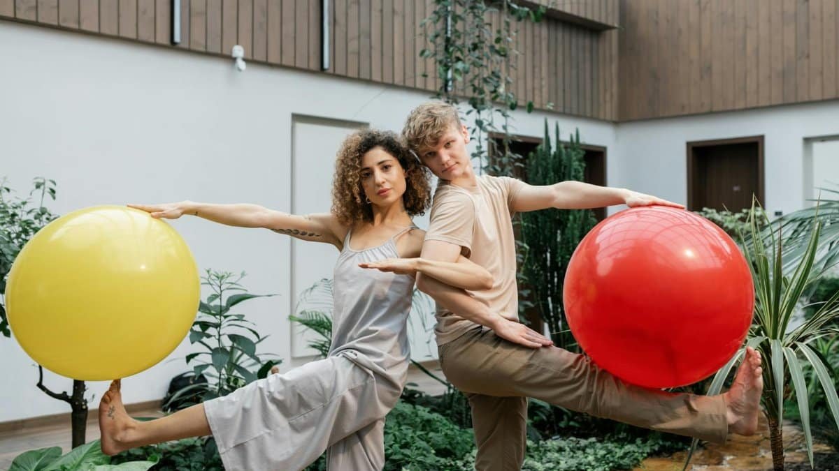 Couple balancing with yoga balls indoors. Harmony, balance, and fitness captured in a serene setting.
