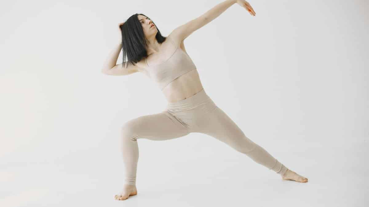 Elegant woman practicing yoga in a serene indoor setting, emphasizing fitness and flexibility.