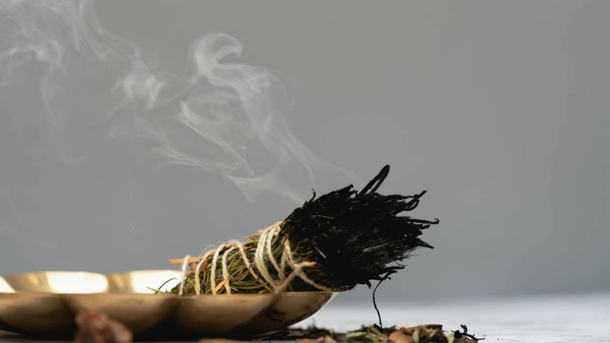 Calm and spiritual atmosphere with sage smudge burning in a ritual setting.
