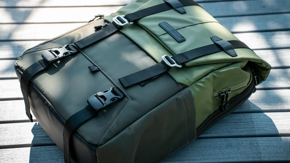 A durable green backpack with straps, perfect for outdoor adventures, resting on wooden planks.