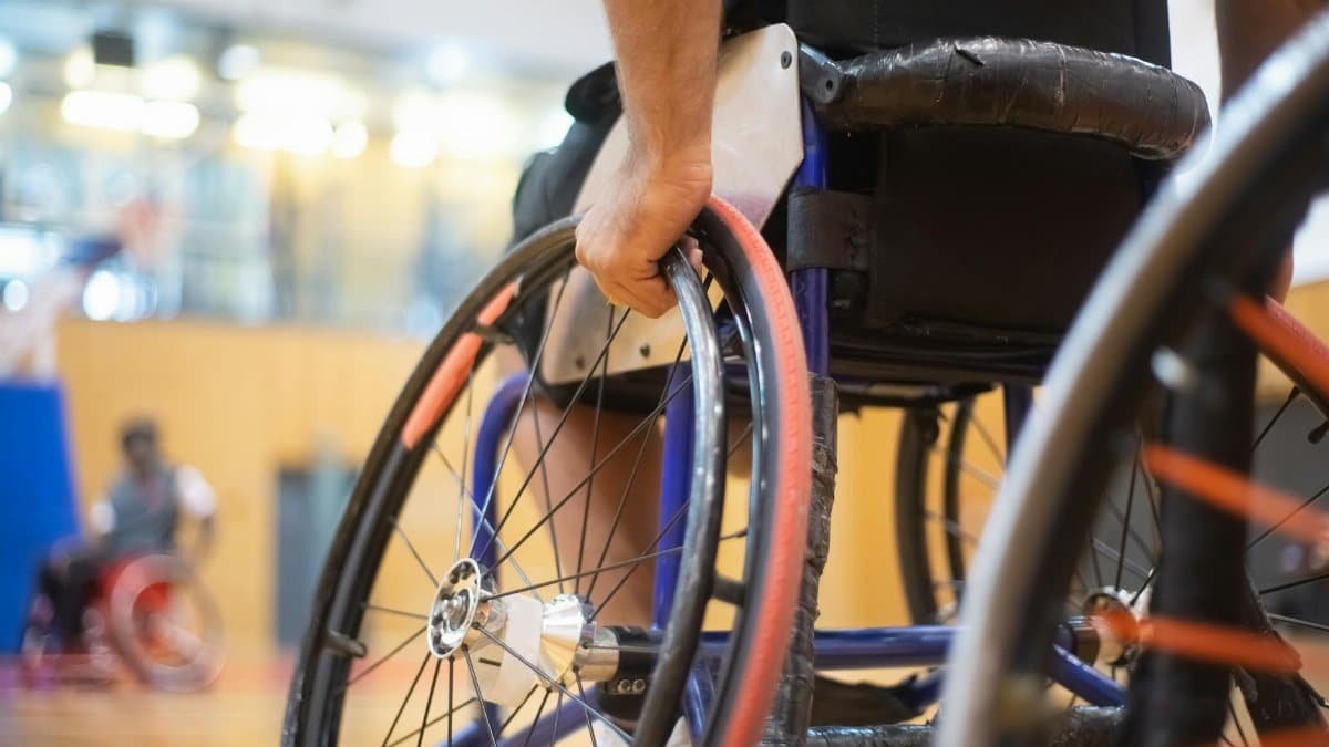 Dynamic close-up of a basketball player in a wheelchair during a game, focusing on athleticism.