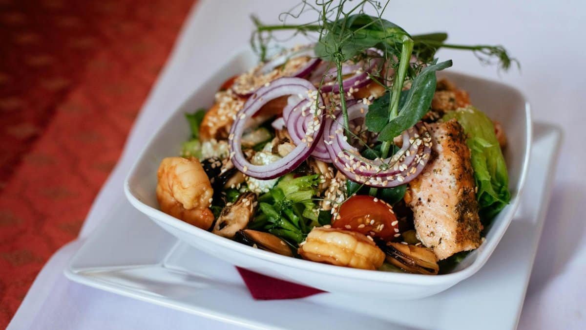 Delicious seafood salad with salmon and shrimp, garnished with fresh greens and onions.