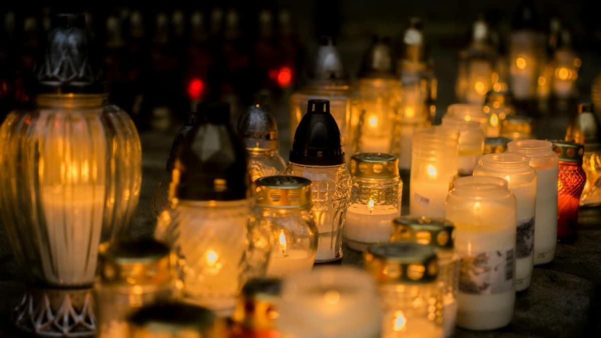 Lit candles on a grave, a serene tribute for All Saints' Day, Poland.