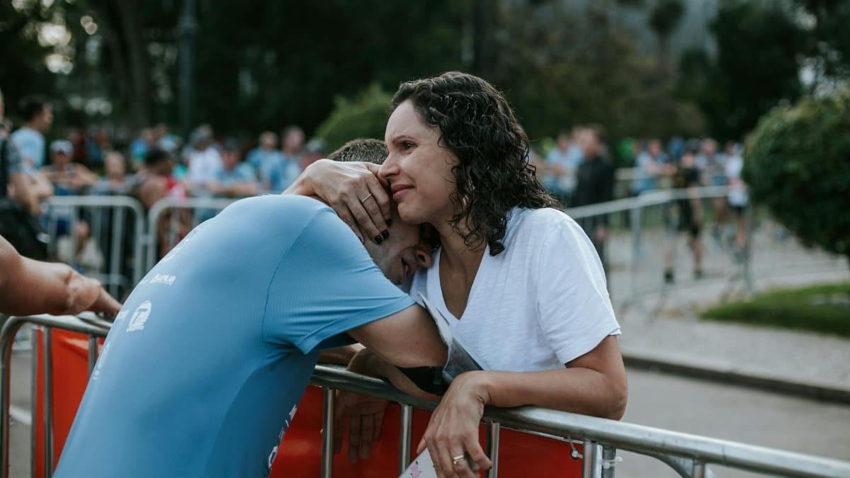 An emotional embrace between two adults at an outdoor event provides a touching moment.