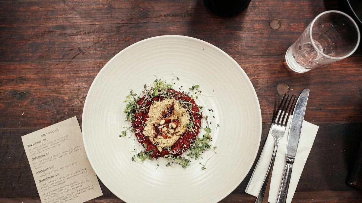 Elegant quinoa salad with microgreens served in a restaurant, captured in a top-down view.