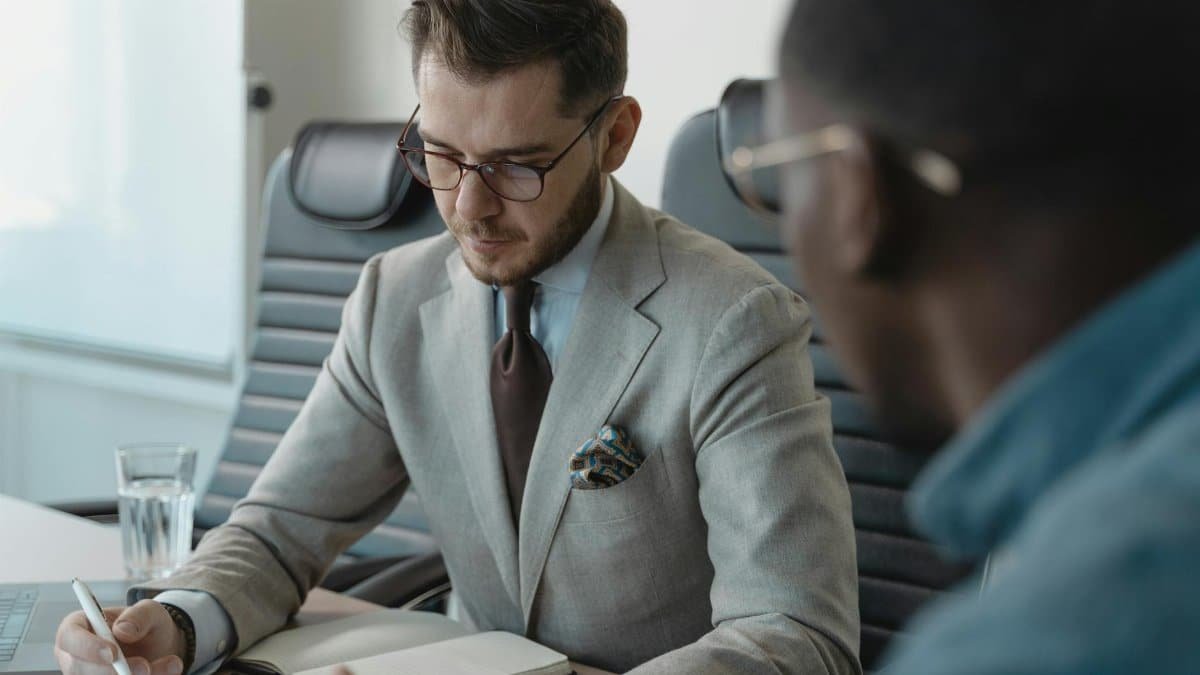 Two professionals having a focused discussion during a business meeting in an office setting.