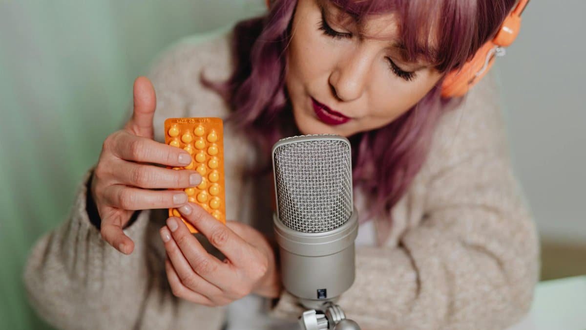 ASMR artist using a microphone and headphones while engaging with tactile objects for sensory content creation.