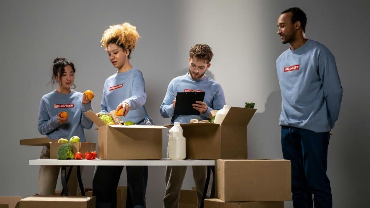 A diverse group of volunteers organizing and packing food donations at an indoor facility.