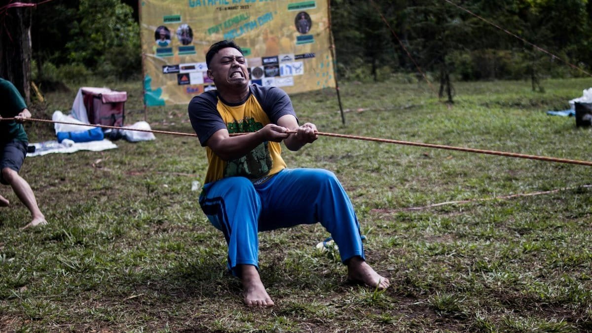 Energetic tug of war competition outdoors showcasing teamwork and physical strength.
