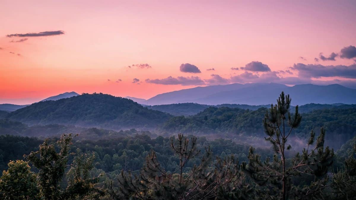 Stunning mountain landscape at sunset with fog and vibrant colors.