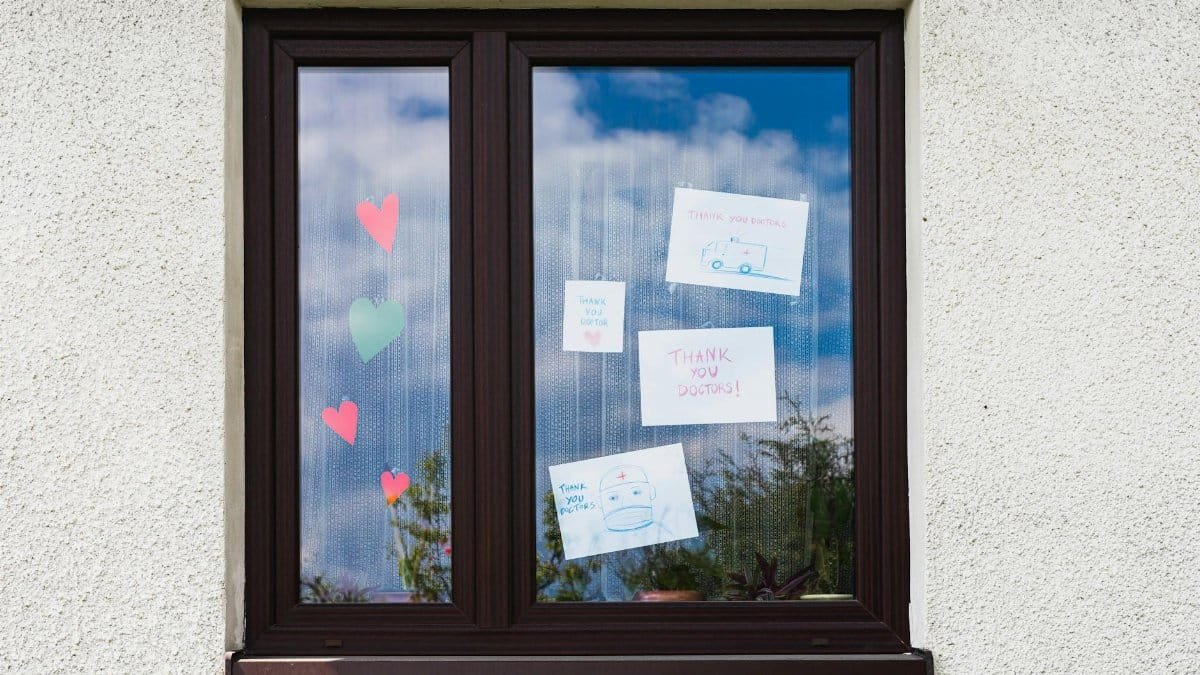 Handwritten notes and hearts on a window express gratitude to doctors.
