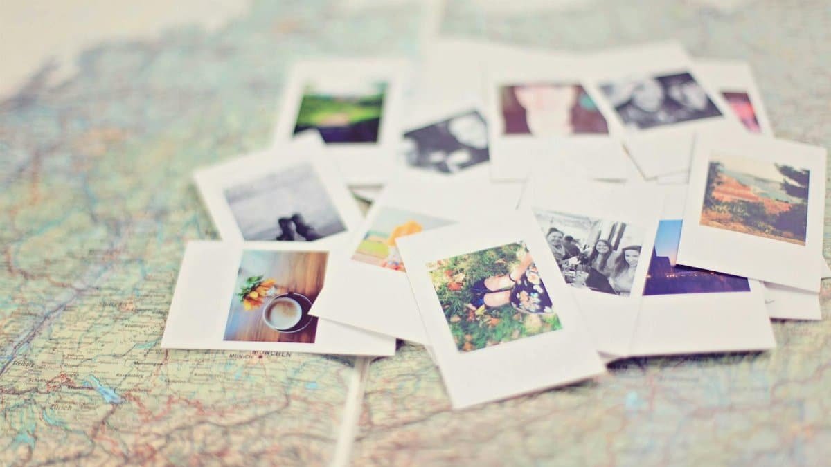 A collection of Polaroid memories spread across a map, symbolizing travel adventures.