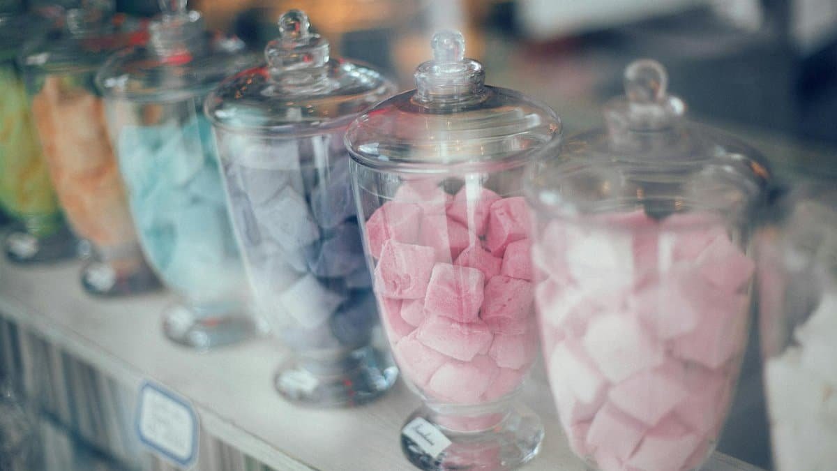 Vibrant assortment of candies in jars, showcasing multicolored confections with soft hues.