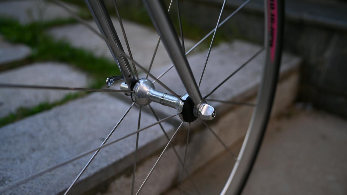 A detailed view of a bicycle wheel's hub and spokes on stone steps, perfect for cycling enthusiasts.