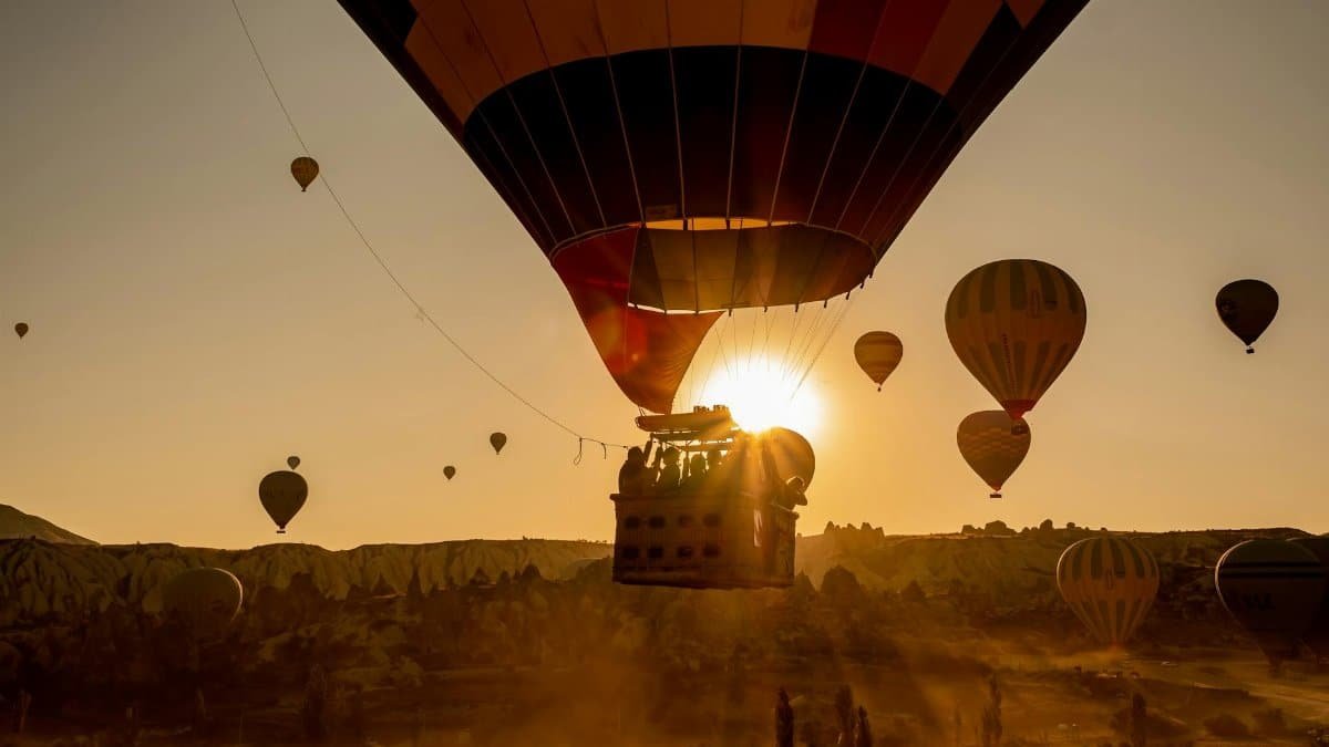 Scenic view of hot air balloons floating over Cappadocia, Turkey at sunrise.