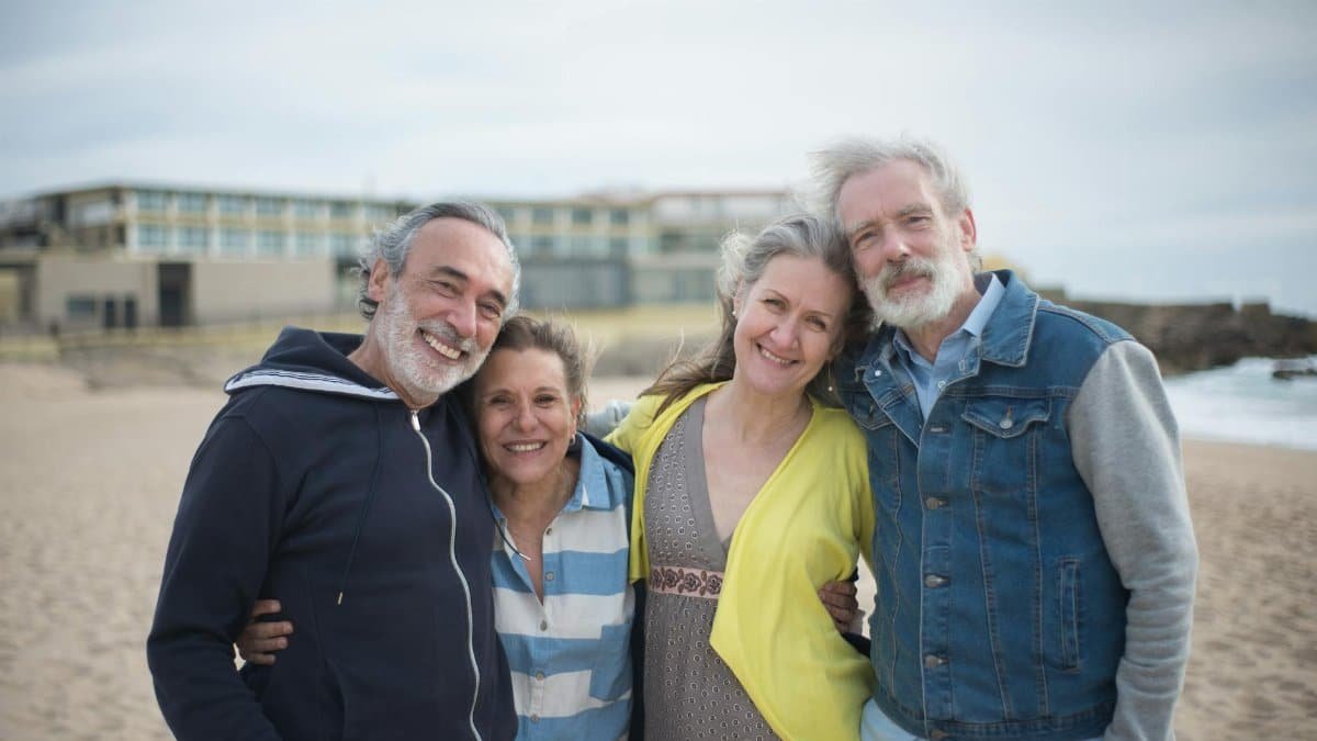 A cheerful group of mature friends enjoying a day at the beach in Portugal, showcasing togetherness.