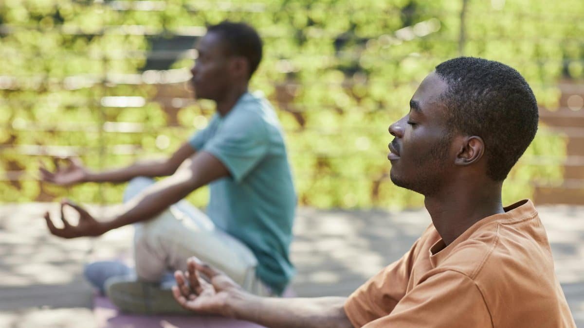 Two men meditating outdoors, capturing a sense of relaxation and mindfulness.