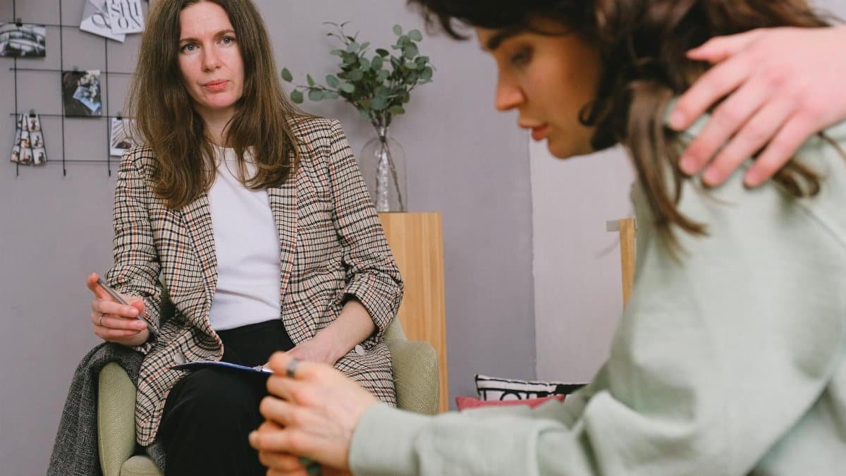 A therapist consults with a couple during a therapy session, providing support.