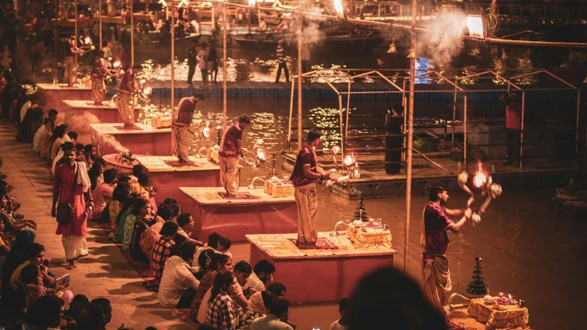 Evening Ganga Aarti ceremony with worshippers on the banks of the Ganges in Varanasi, India.