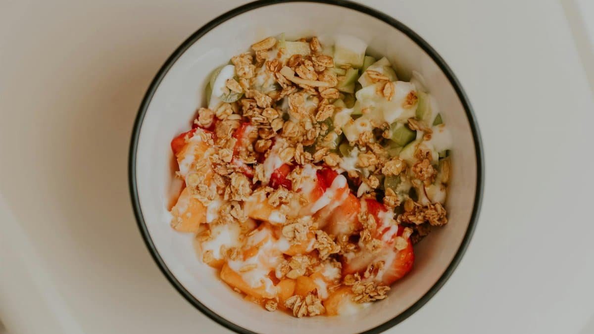 Top view of a delicious granola and fruit bowl with yogurt, perfect for a healthy breakfast.