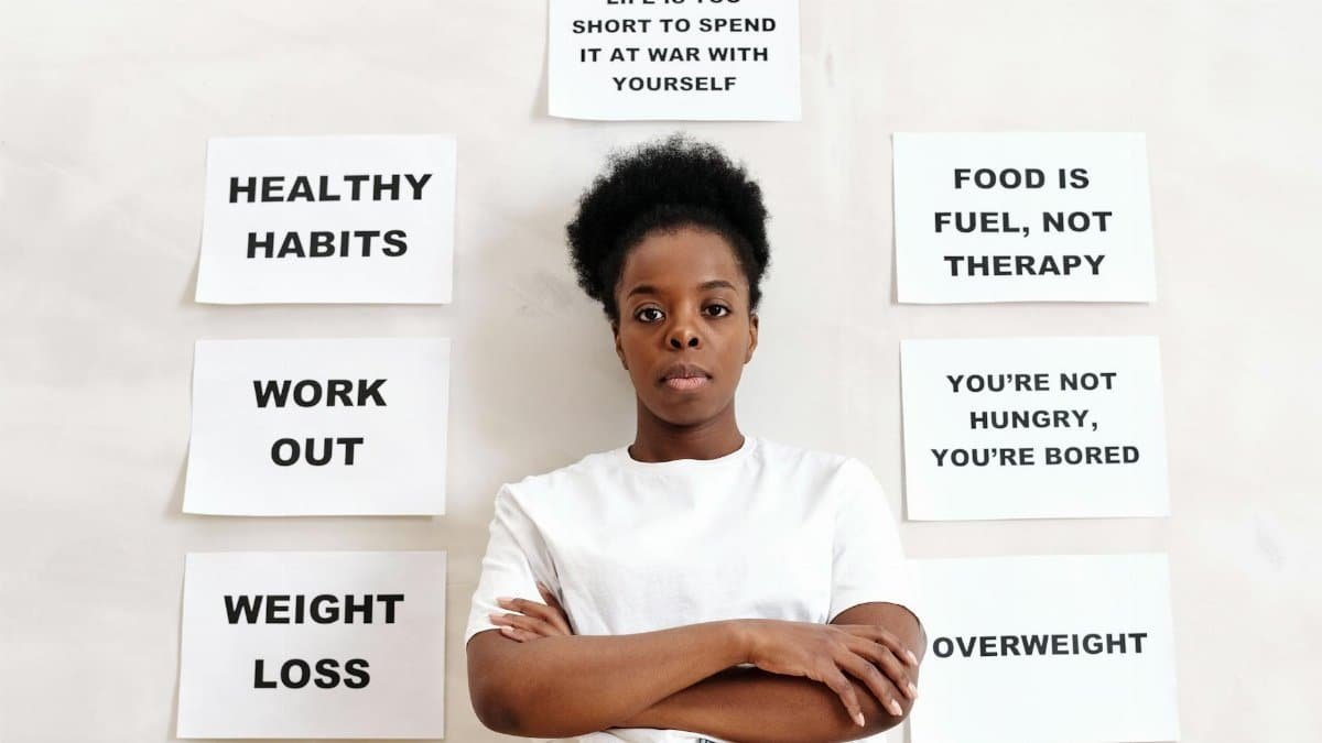 Confident woman stands surrounded by motivational messages about healthy living.