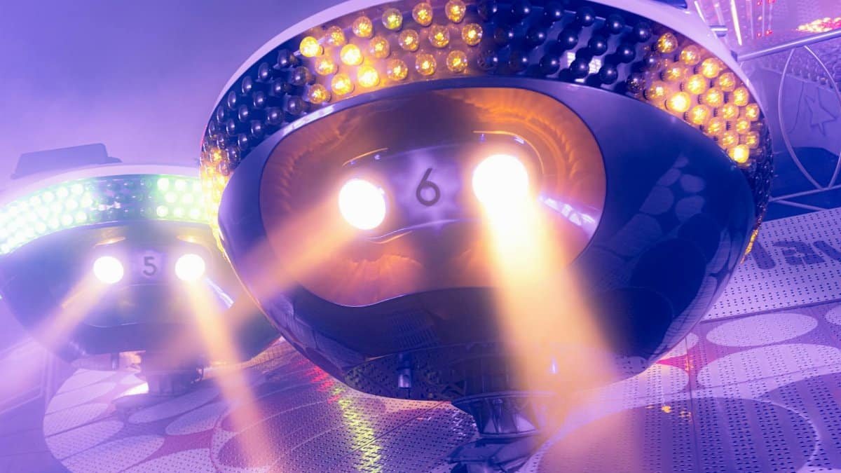 Vibrant illuminated amusement park ride lights creating a festive atmosphere at night.