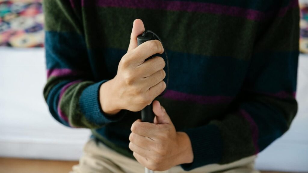 A close-up image showing hands holding a walking stick for balance or support.