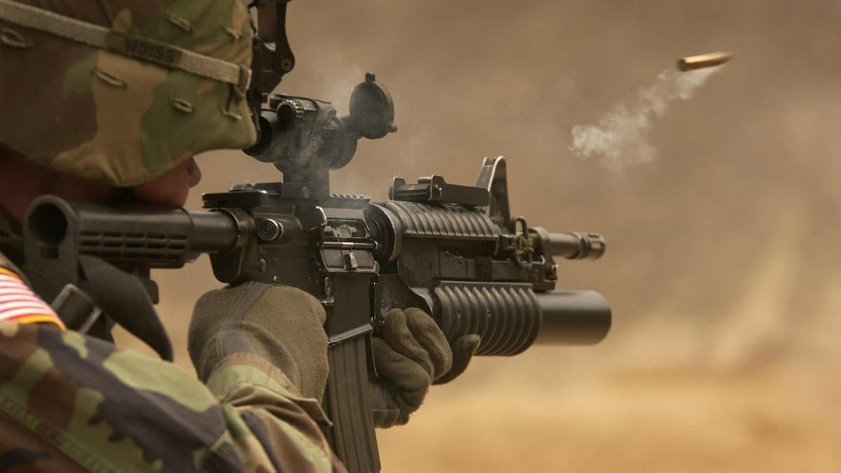 Close-up of a soldier in camo firing a rifle in action during training.