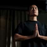 An adult male practicing meditation in a yoga studio, focusing on mindfulness and wellbeing.