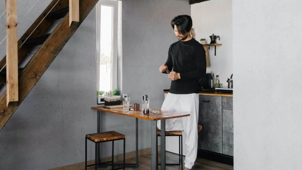 Man in modern kitchen preparing a beverage, promoting peaceful home routines.