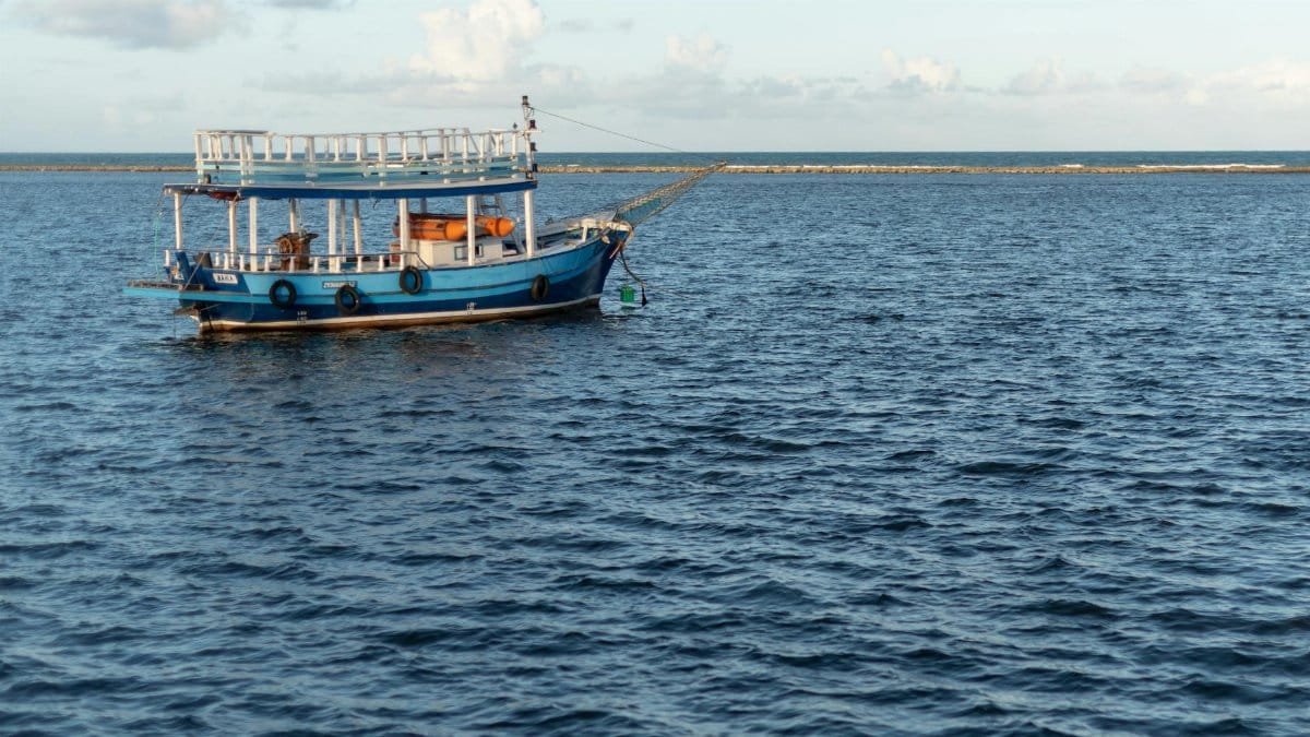 A tranquil scene of a blue boat on the ocean at Arraial d'Ajuda, Bahia, Brazil.