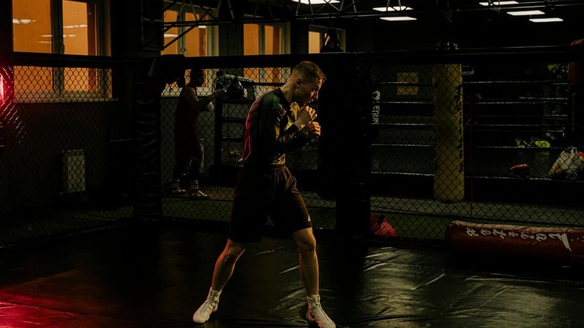 A dedicated boxer honing his skills in a dimly lit boxing gym, showcasing intense focus.